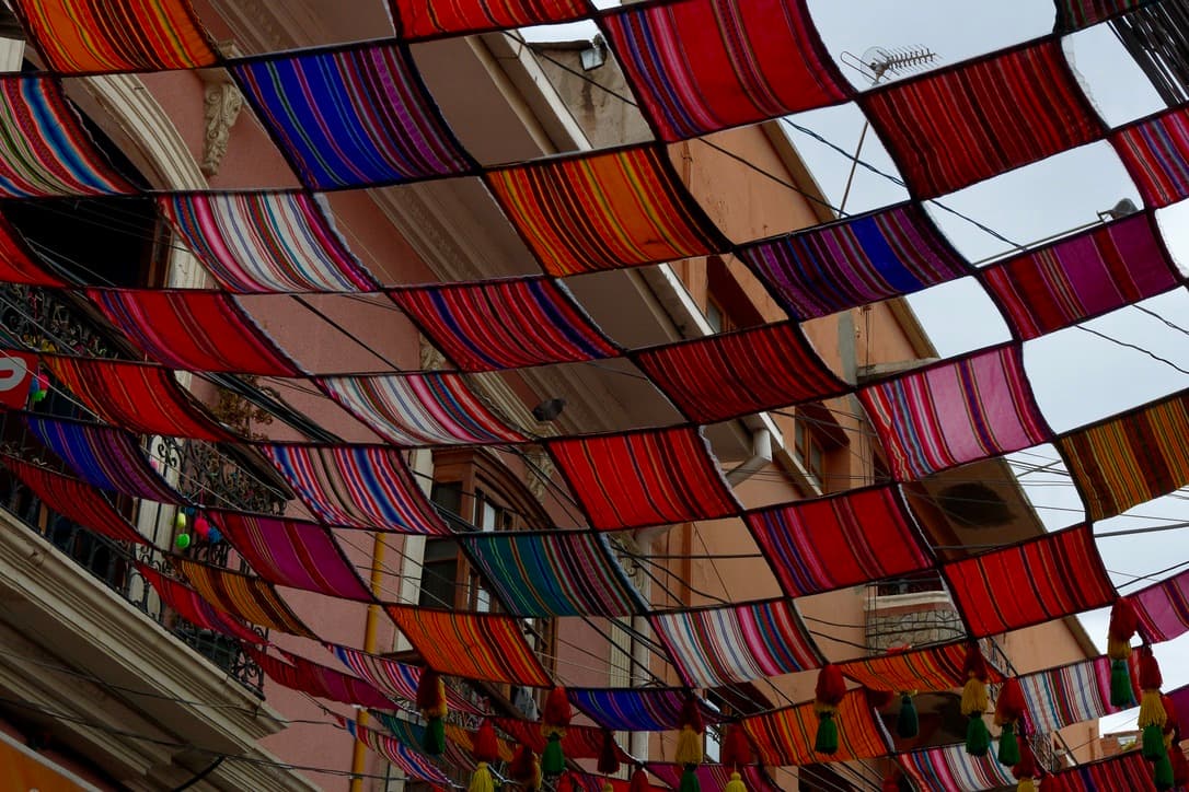 colorful woven cloths hung over a street