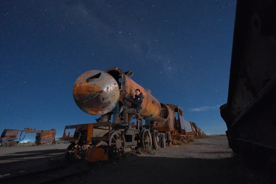 a rusted locomotive under a starry sky