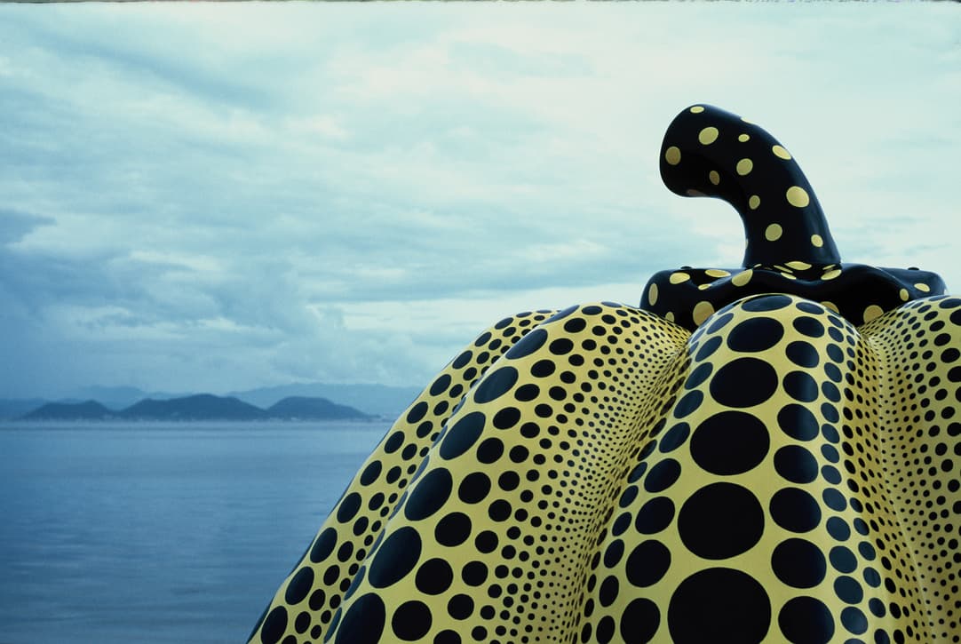 the black-dotted pumpkin up close, with the sea and islands behind